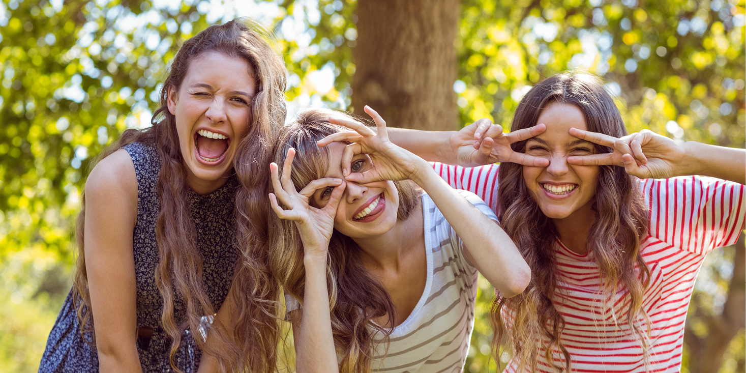 Das Bild zeigt drei junge Frauen die mit viel Spass und lustigen Gesten in die Kamera schauen